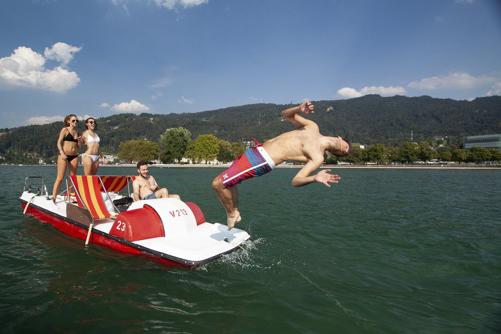 Ein junger Mann springt vom Tretboot in den Bodensee