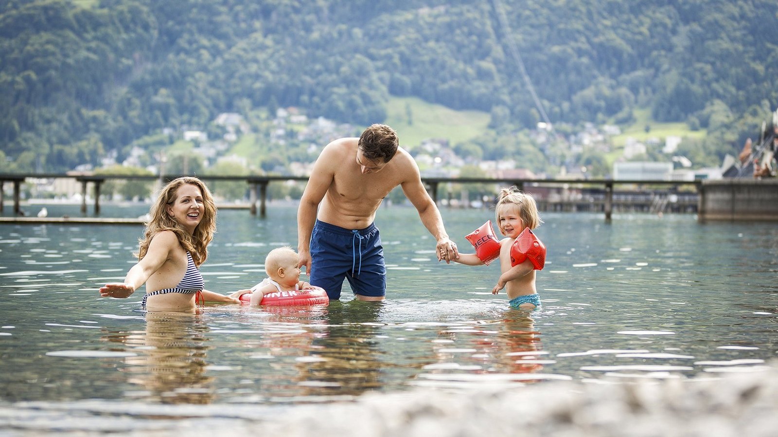 Eine junge Familie planscht im Wasser des Bodensees im Strandbad Bregenz