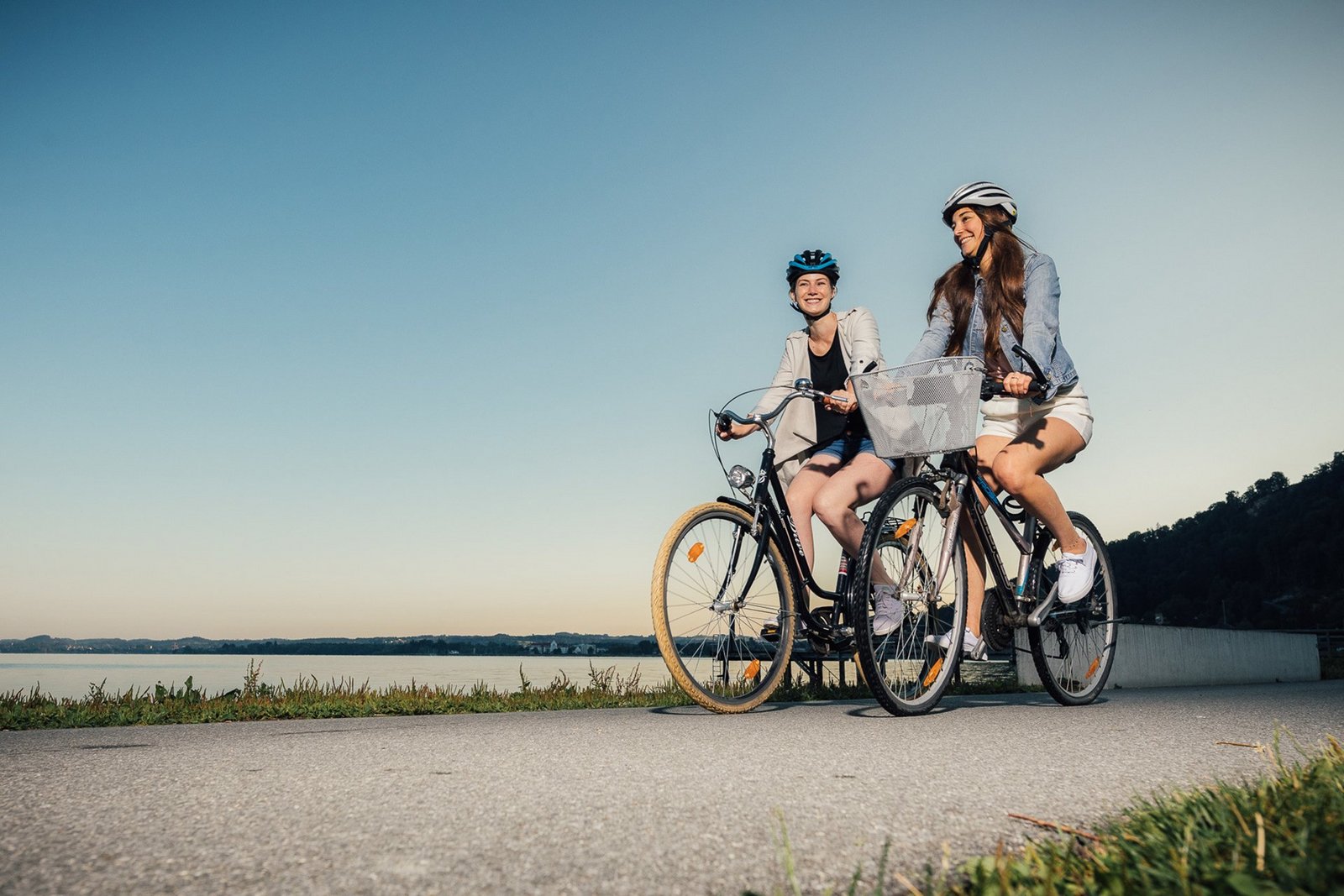 Zwei Frauen fahren mit dem Fahrrad am See