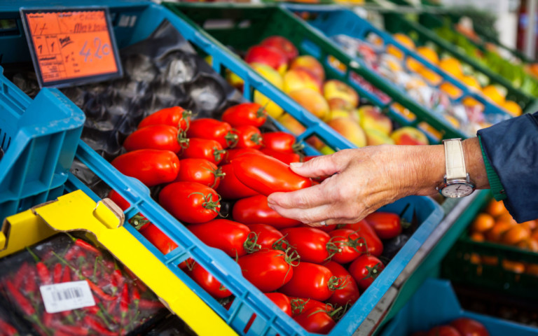 Hand mit Tomate beim Markt
